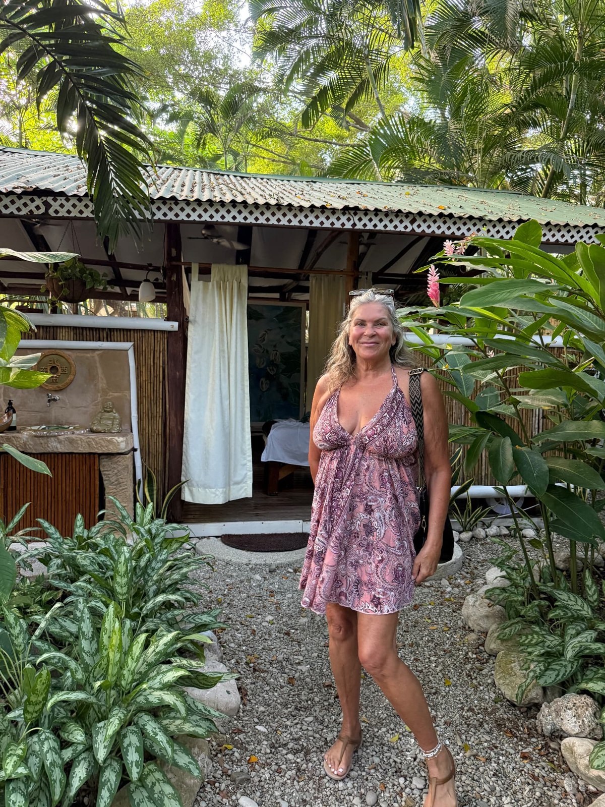 Lori surrounded by lush tropical plants